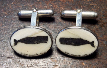 Mammoth Ivory Cufflinks With Black Whale Silhouettes On a Cream Background